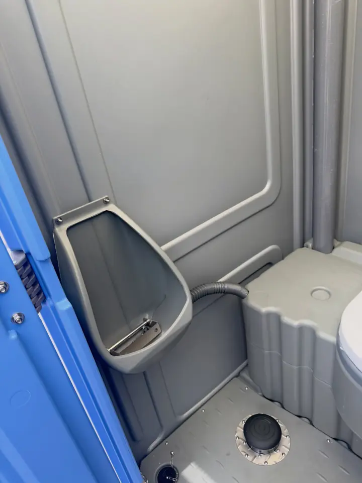 Urinal inside a portable toilet next to the seat