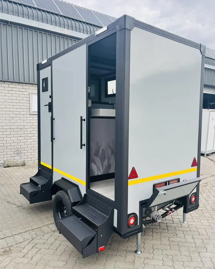 Restroom trailer with one door open showing the interior