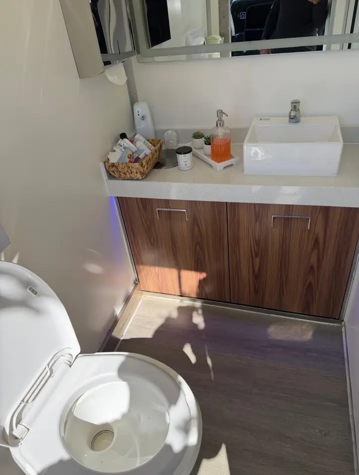 Close view of VIP trailer vanity with soap, lotion and toilet